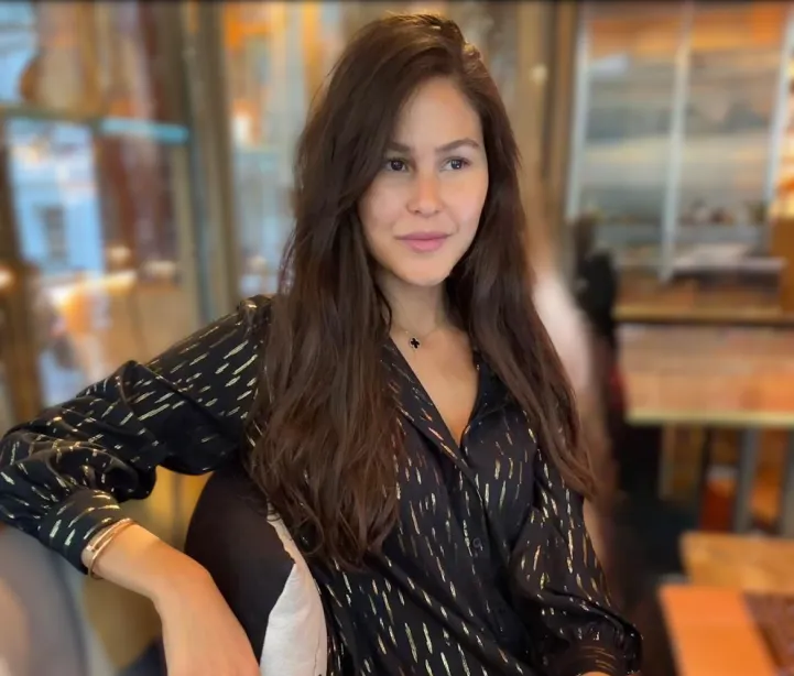 Torkia cofounder of Ovasave in a black and gold shirt sitting in a chair.